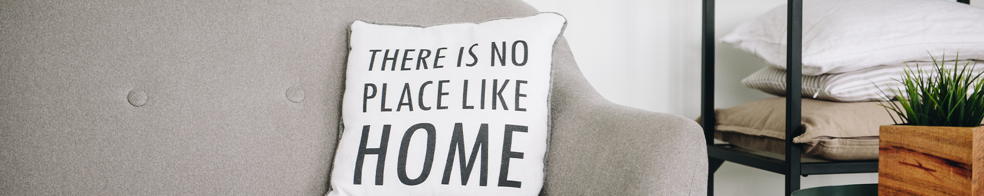 white pillow with text on grey couch